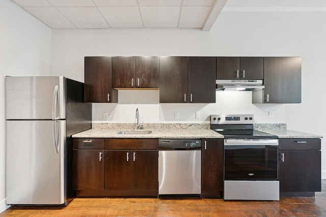 2 Main St Unit 17-415, Biddeford, ME 04005 - kitchen featuring appliances with stainless steel finishes, under cabinet range hood, wood finished floors, dark brown cabinetry, and a drop ceiling