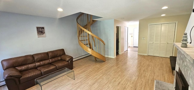 9 Hubbard Farms Rd Unit 15, Orono, ME 04473 - living area featuring stairway, light wood finished floors, a fireplace, a baseboard heating unit, and recessed lighting