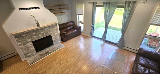 9 Hubbard Farms Rd Unit 15, Orono, ME 04473 - living area featuring a baseboard heating unit, wood finished floors, healthy amount of natural light, and a brick fireplace