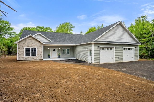 18 Crestwood Dr, Orrington, ME 04474 - ranch-style home with an attached garage, a porch, asphalt driveway, roof with shingles, and stone siding