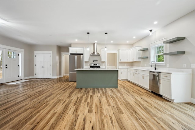 18 Crestwood Dr, Orrington, ME 04474 - kitchen featuring wall chimney range hood, appliances with stainless steel finishes, open shelves, light countertops, and a kitchen island