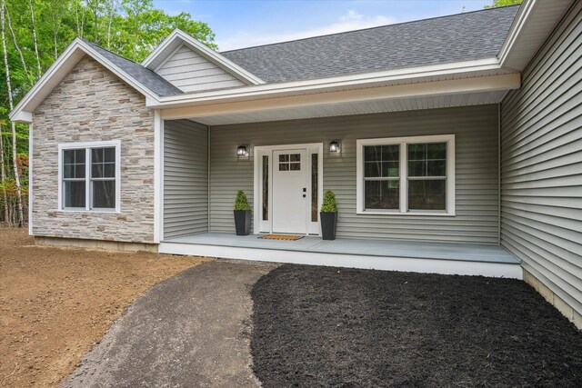 18 Crestwood Dr, Orrington, ME 04474 - property entrance with stone siding, a porch, and a shingled roof