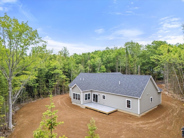 18 Crestwood Dr, Orrington, ME 04474 - rear view of property with dirt driveway, roof with shingles, a view of trees, and a deck