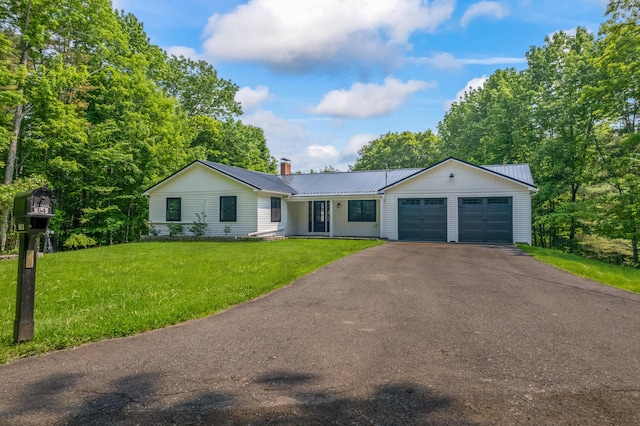 64 Old Pond Rd, Dexter, ME 04930 - single story home with a garage, asphalt driveway, a front lawn, a metal roof, and a chimney