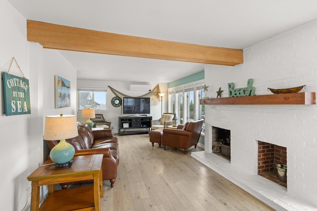 265 Nubble Rd, York, ME 03909 - living area featuring a fireplace, beam ceiling, wood-type flooring, a wall mounted AC, and plenty of natural light