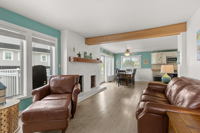 265 Nubble Rd, York, ME 03909 - living room with beam ceiling, light wood-style flooring, a brick fireplace, and ceiling fan