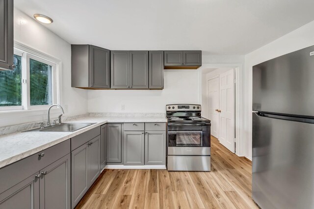 290 Gray Rd, Windham, ME 04062 - kitchen with stainless steel appliances, gray cabinetry, and light wood-type flooring