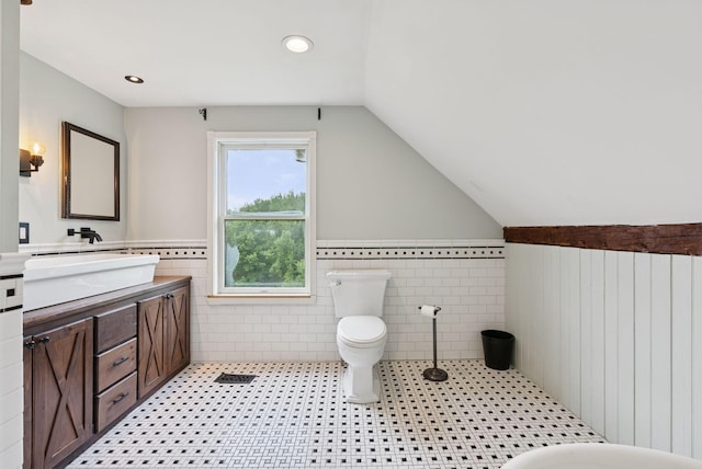 30 Graffam Rd, Baldwin, ME 04091 - full bathroom featuring vanity, wainscoting, tile walls, vaulted ceiling, and tile patterned flooring