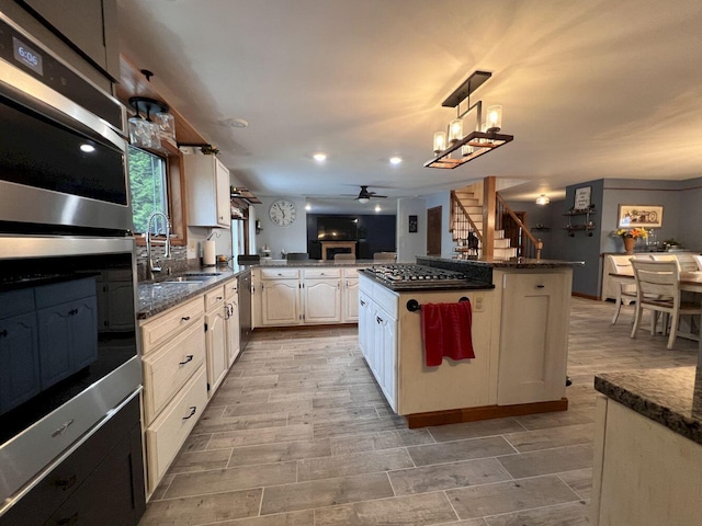 227 Back Rd, Skowhegan, ME 04976 - kitchen with ceiling fan, stainless steel appliances, open floor plan, hanging light fixtures, and dark stone countertops
