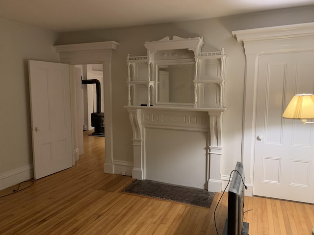 11 Gardner Ave, Machias, ME 04654 - unfurnished bedroom featuring wood finished floors, a wood stove, and heating unit