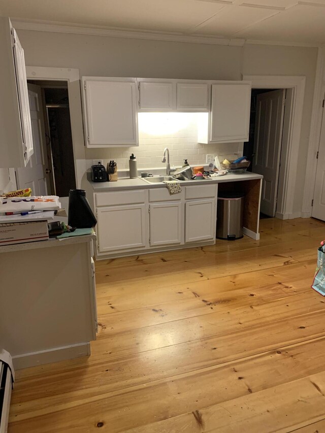 11 Gardner Ave, Machias, ME 04654 - kitchen featuring ornamental molding, white cabinets, light wood-type flooring, backsplash, and light countertops