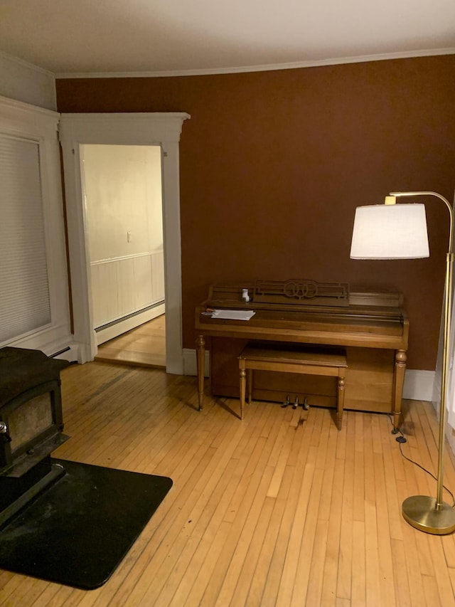 11 Gardner Ave, Machias, ME 04654 - office featuring a wood stove, a baseboard radiator, hardwood / wood-style floors, and crown molding