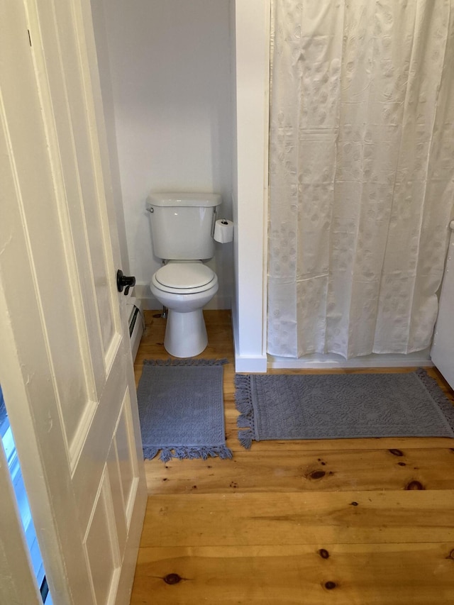 11 Gardner Ave, Machias, ME 04654 - bathroom featuring wood finished floors, a baseboard radiator, and curtained shower