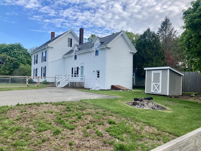 11 Gardner Ave, Machias, ME 04654 - back of house featuring a storage unit and a chimney