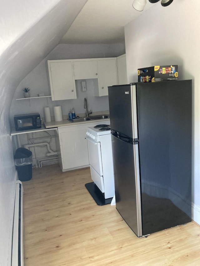 11 Gardner Ave, Machias, ME 04654 - kitchen with freestanding refrigerator, white electric range, white cabinets, light wood-style floors, and vaulted ceiling