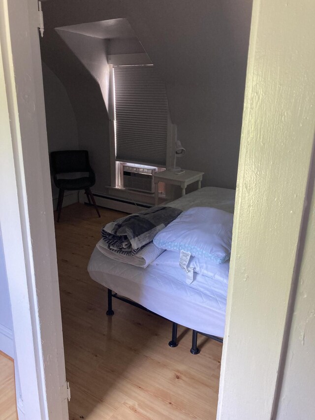 11 Gardner Ave, Machias, ME 04654 - bedroom featuring wood finished floors, a baseboard radiator, and cooling unit