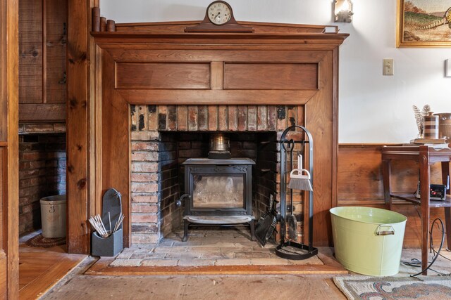 507 Ford Quint Rd, North Berwick, ME 03906 - detailed view of a wood stove, wood finished floors, wainscoting, and wooden walls