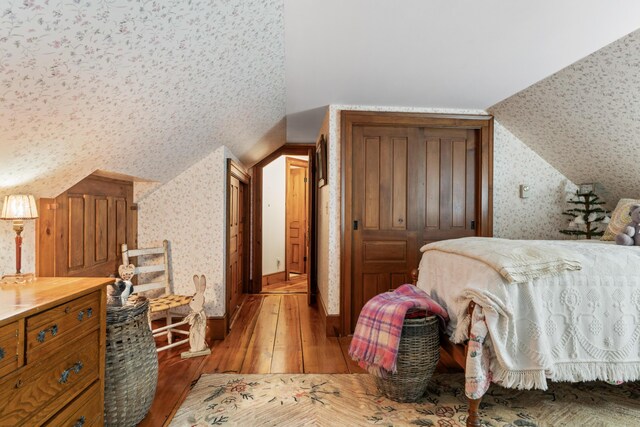 507 Ford Quint Rd, North Berwick, ME 03906 - bedroom with wallpapered walls, light wood-type flooring, and lofted ceiling