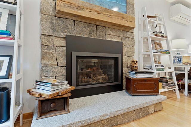 26 Ferncroft Rd, York, ME 03909 - detailed view of a wall mounted AC, wood finished floors, and a glass covered fireplace