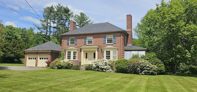 91 Mayflower Hill Dr, Waterville, ME 04901 - georgian-style home with a chimney, driveway, an attached garage, and a front lawn