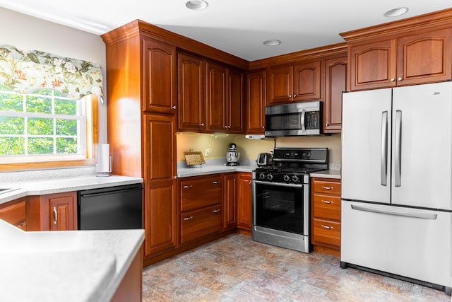 627 Green Lake Rd, Dedham, ME 04429 - kitchen featuring freestanding refrigerator, stainless steel microwave, gas range, light countertops, and stone finish flooring