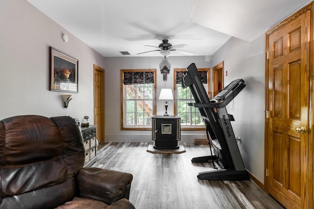 627 Green Lake Rd, Dedham, ME 04429 - workout area featuring a wood stove, wood finished floors, and ceiling fan