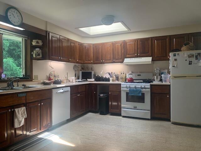 48 13th St, Bangor, ME 04401 - kitchen featuring white appliances, under cabinet range hood, light countertops, and dark brown cabinets
