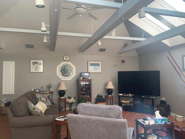 48 13th St, Bangor, ME 04401 - living room with a skylight, beam ceiling, ceiling fan, tile patterned flooring, and high vaulted ceiling