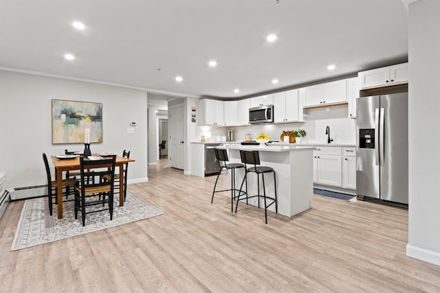 16 Guilford Ct Unit B1, Portland, ME 04101 - kitchen with stainless steel appliances, light countertops, a kitchen island, recessed lighting, and a breakfast bar area