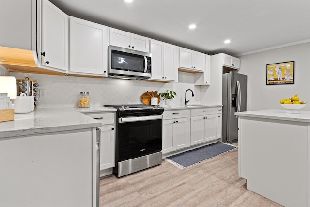 16 Guilford Ct Unit B1, Portland, ME 04101 - kitchen with stainless steel appliances, light wood finished floors, backsplash, white cabinets, and crown molding