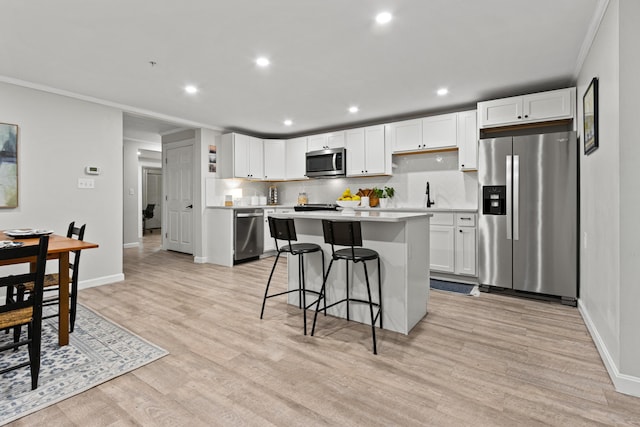 16 Guilford Ct Unit B1, Portland, ME 04101 - kitchen with stainless steel appliances, light countertops, recessed lighting, light wood-style floors, and a kitchen breakfast bar