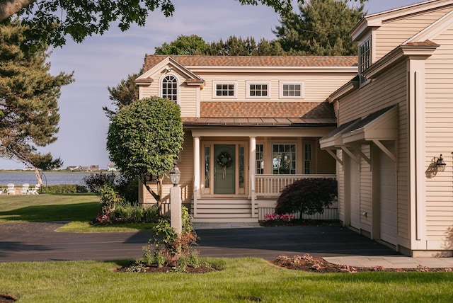 22 Channel Cove Ln, Biddeford, ME 04005 - view of front facade featuring roof with shingles, a porch, a front yard, and a water view