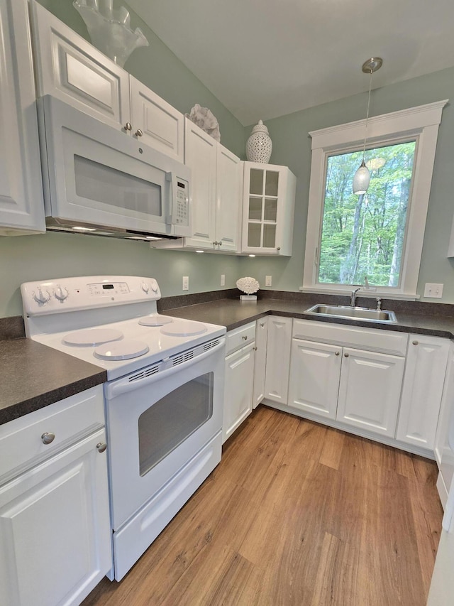 1 Old County Rd Unit 140, Wells, ME 04090 - kitchen with white appliances, dark countertops, light wood-type flooring, and white cabinetry
