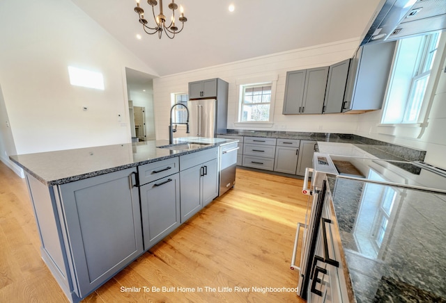 5 Whitetail St, Belfast, ME 04915 - kitchen featuring appliances with stainless steel finishes, gray cabinetry, lofted ceiling, an island with sink, and dark stone countertops