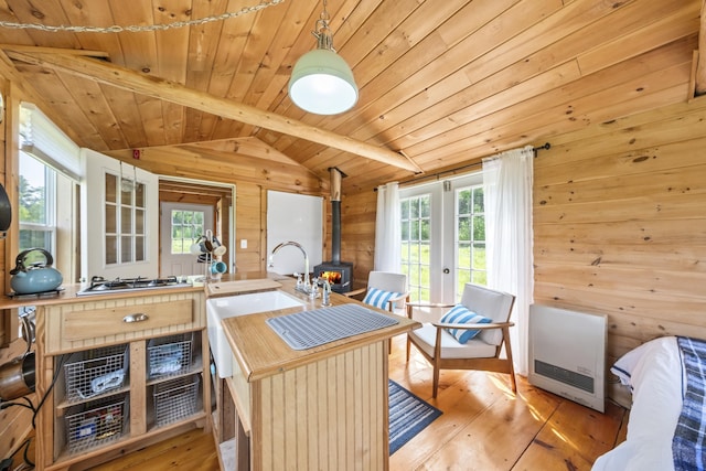 1535 Bailey Rd, Knox, ME 04986 - kitchen featuring heating unit, a wood stove, wood walls, plenty of natural light, and wood ceiling