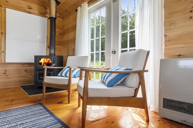 1535 Bailey Rd, Knox, ME 04986 - sitting room featuring a wood stove, wood walls, wood finished floors, and heating unit