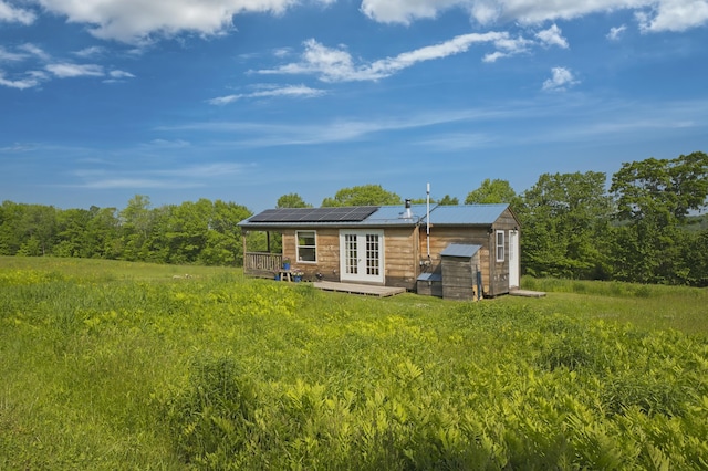 1535 Bailey Rd, Knox, ME 04986 - rear view of property with french doors, a storage shed, a metal roof, and solar panels