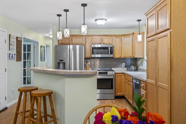 47 Double M Ln, Woolwich, ME 04579 - kitchen with appliances with stainless steel finishes, light wood-style floors, tasteful backsplash, light countertops, and hanging light fixtures