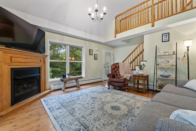 47 Double M Ln, Woolwich, ME 04579 - living area featuring a baseboard radiator, a chandelier, a glass covered fireplace, high vaulted ceiling, and stairs