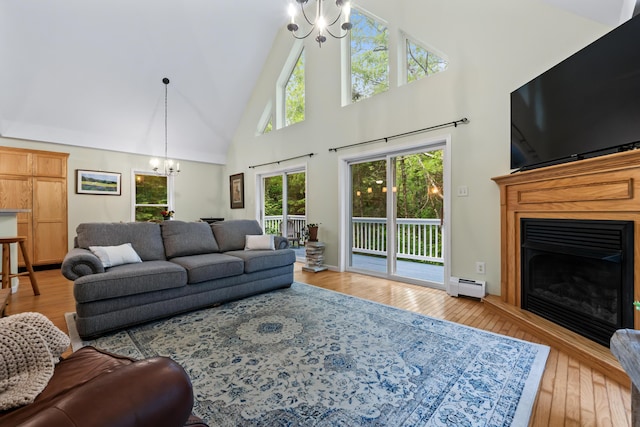 47 Double M Ln, Woolwich, ME 04579 - living area featuring a chandelier, high vaulted ceiling, baseboard heating, wood-type flooring, and a fireplace