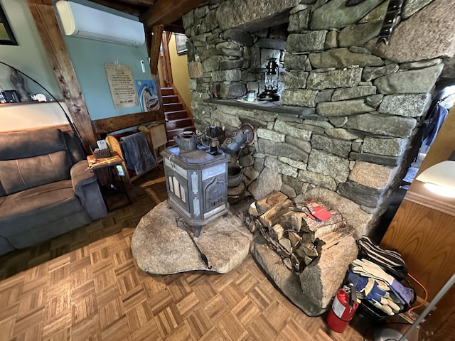 396 Smyrna Town Line Rd, Smyrna, ME 04780 - living room featuring an AC wall unit, a wood stove, and stairway