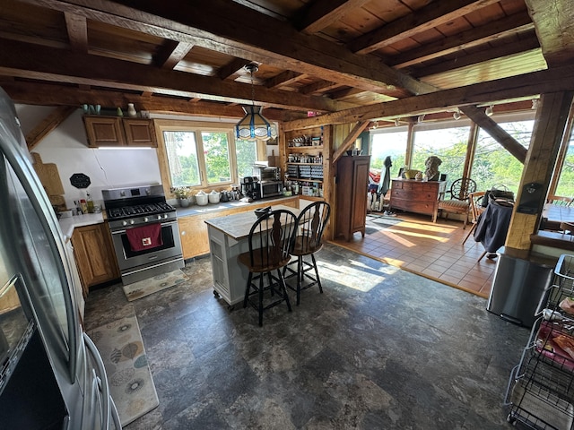 396 Smyrna Town Line Rd, Smyrna, ME 04780 - kitchen featuring stainless steel appliances, light countertops, a breakfast bar, a kitchen island, and a wooden ceiling with exposed beams