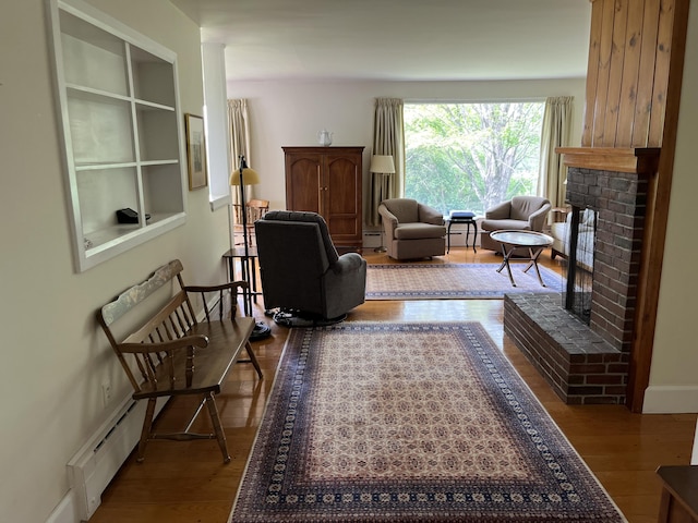 241 Bristol Rd, Damariscotta, ME 04543 - living room with a fireplace, wood finished floors, and a baseboard radiator