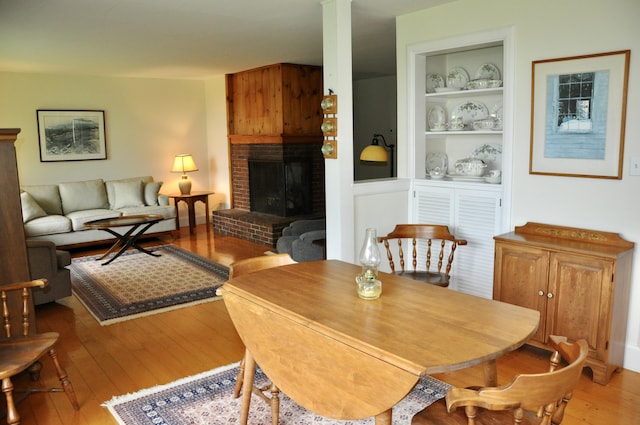 241 Bristol Rd, Damariscotta, ME 04543 - dining space featuring hardwood / wood-style flooring, a brick fireplace, and built in shelves