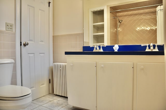 241 Bristol Rd, Damariscotta, ME 04543 - bathroom with radiator heating unit, tile walls, vanity, tiled shower, and tile patterned floors