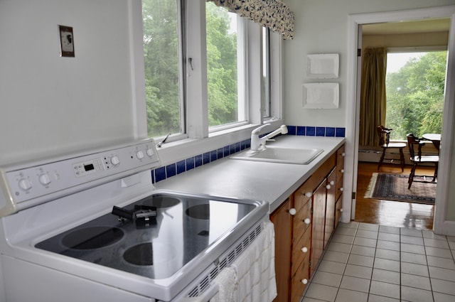 241 Bristol Rd, Damariscotta, ME 04543 - kitchen with white electric stove, light tile patterned floors, brown cabinetry, light countertops, and baseboard heating