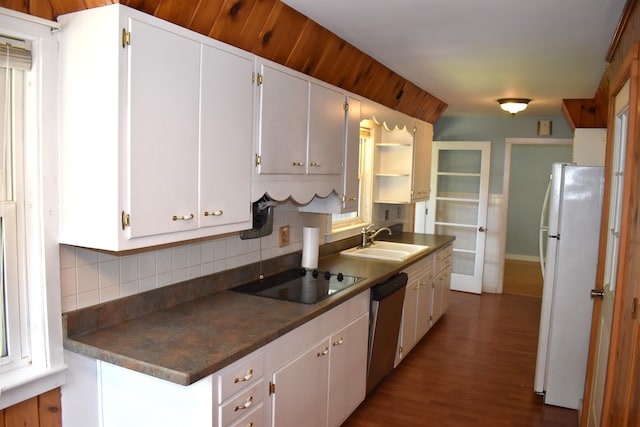 25 Ariel St, Lincoln, ME 04457 - kitchen with freestanding refrigerator, black electric cooktop, stainless steel dishwasher, backsplash, and dark countertops