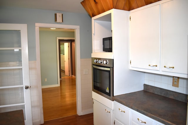 25 Ariel St, Lincoln, ME 04457 - kitchen featuring oven, dark countertops, dark wood finished floors, white cabinetry, and tile walls