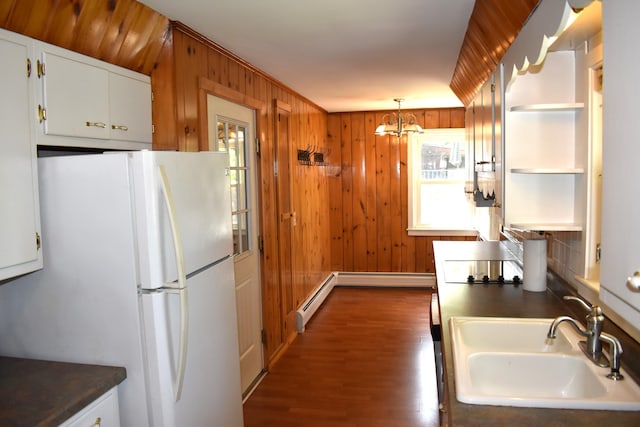 25 Ariel St, Lincoln, ME 04457 - kitchen with freestanding refrigerator, baseboard heating, plenty of natural light, and wood walls