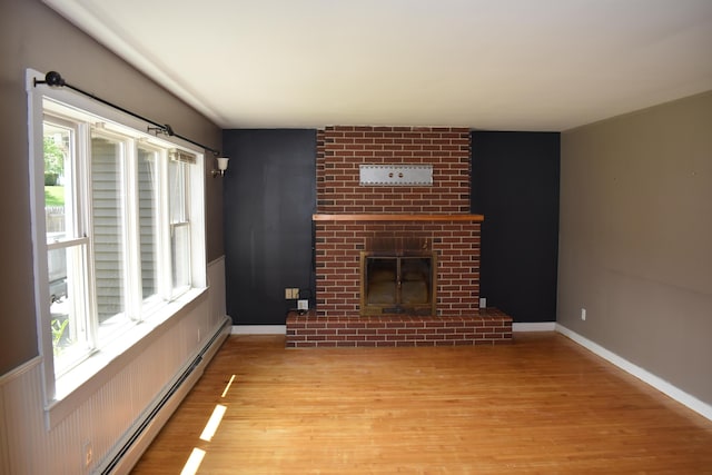 25 Ariel St, Lincoln, ME 04457 - unfurnished living room featuring baseboard heating, wood finished floors, and a fireplace